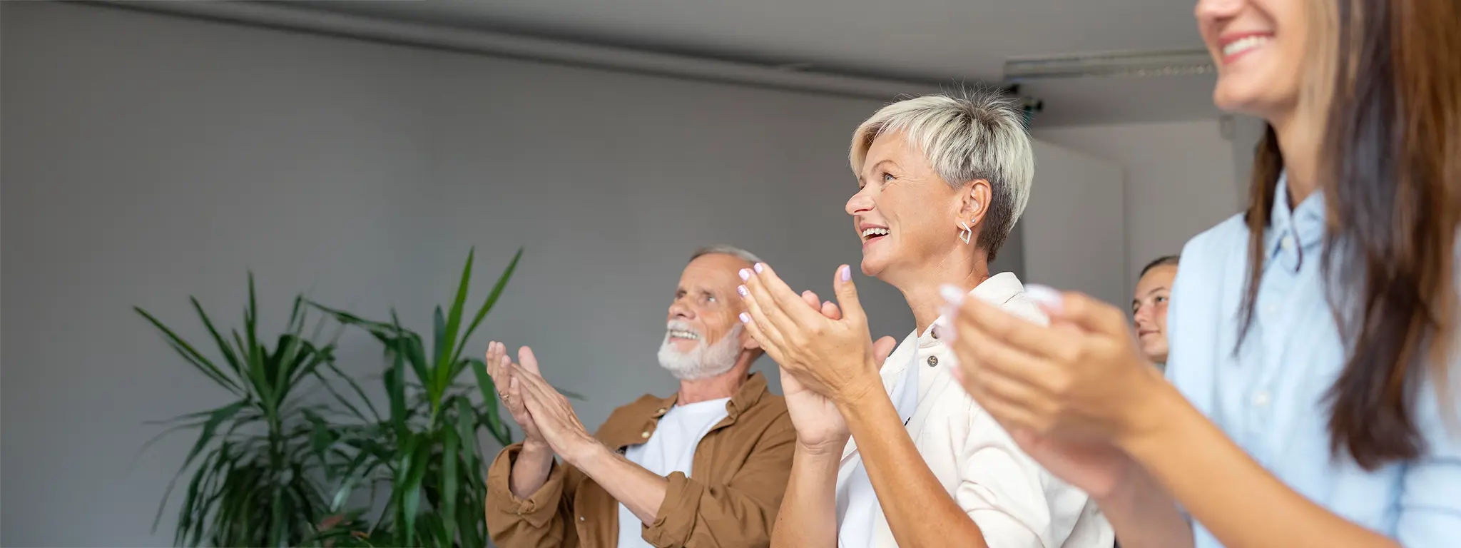 Applaus im Seminarraum des Fördervereins des ev. Fachseminars für Pflegeberufe e.V. Drei Personen klatschen in einem Seminarraum.